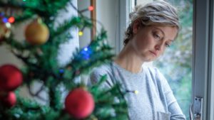 Sad woman next to Christmas tree